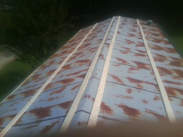 Rusted metal roof panels with new wood purlins before replacement — Storm Damage Roof Repair in Evans City by Roofing Brothers