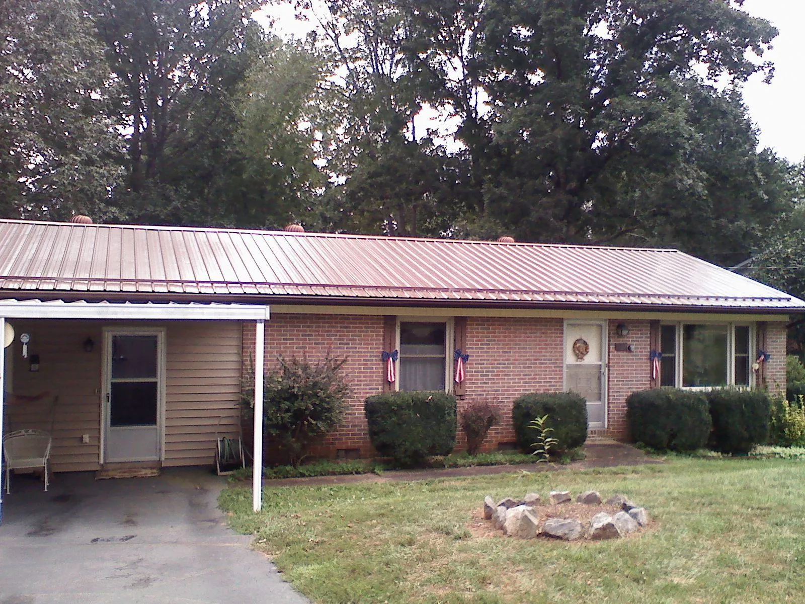 Bronze metal roof and carport on a brick ranch home — Roof Repair work by our crew in Evans City